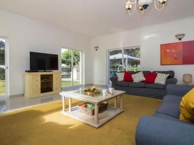 a living room with a blue couch and a tv at Vilamoura Golf Mansion by Stay ici Algarve Holiday Rental in Quarteira
