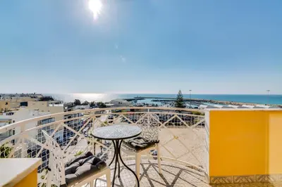 a balcony with a table and a view of the ocean at AL - Ocean Wide View in Quarteira