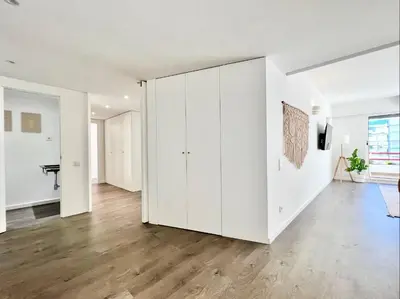 an empty living room with white cabinets and wood floors at Home Out Vilamoura 20 Levante in Vilamoura