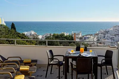 a table and chairs on a balcony with a view of the ocean at RoofTop OldTown Residence in Albufeira