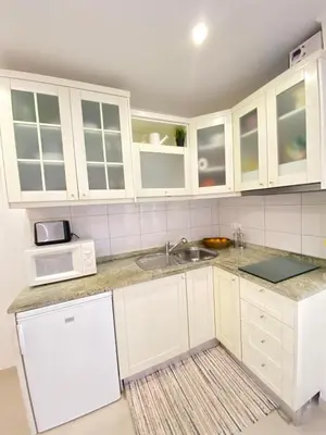 a kitchen with white cabinets and a sink at Casa da Bertha in Albufeira