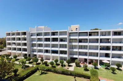 an apartment building with a park in front of it at Pé do Lago Apartment - Condominium - Pool in Quarteira