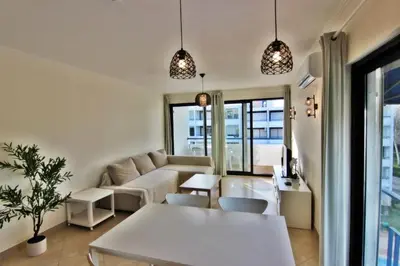 a living room with a couch and a table at Pé do Lago Apartment - Condominium - Pool in Quarteira