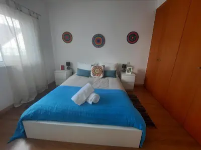 a bedroom with a blue and white bed with two pillows at Casa Mandala, T1 com piscina in Albufeira