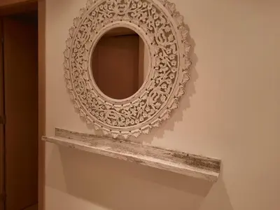 a mirror hanging on a wall with a shelf at Casa Mandala, T1 com piscina in Albufeira