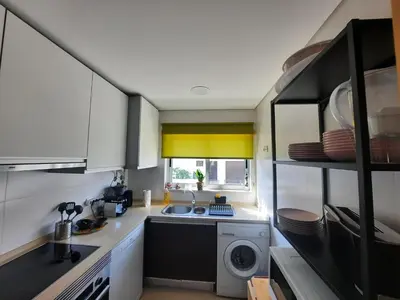 a kitchen with a sink and a washing machine at Casa Mandala, T1 com piscina in Albufeira