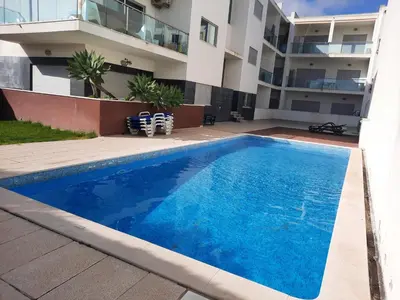 a swimming pool in front of a building at Casa Mandala, T1 com piscina in Albufeira