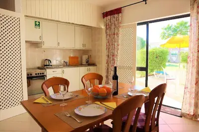 a patio with a table and chairs and an umbrella at Aldeia Joinal - Swimming Pool - FREE WIFI - BY BEDZY in Albufeira