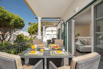 a patio with a table and chairs on a balcony at Casa Ch'i - Vale de Lobo in Almancil