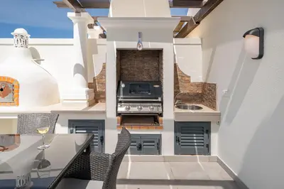 a kitchen with a stove and a dining table at Casa Ch'i - Vale de Lobo in Almancil