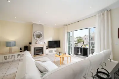 a living room with white furniture and a large window at Casa Ch'i - Vale de Lobo in Almancil