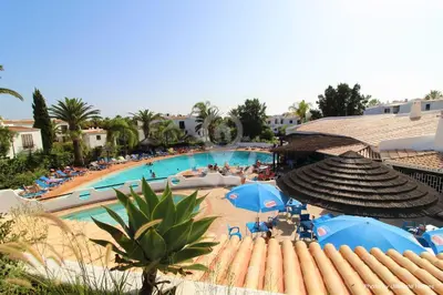 a view of a swimming pool with blue umbrellas at Ocean Dream 84 - Apt. T1 na Praia de São Rafael, Albufeira in Albufeira