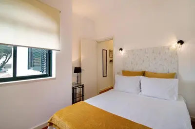 a bedroom with a white bed and a window at Apartamento Medusa by Sunnyway in Olhos de Água