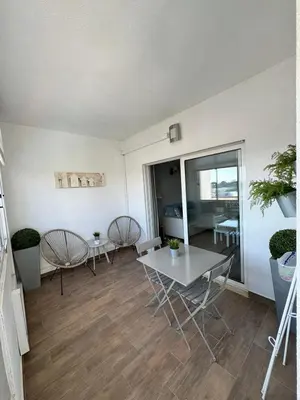 a living room with a table and chairs and a bedroom at Apartamento Oceano in Albufeira