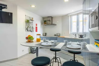 a kitchen with a table with four stools in it at Santa Eulália 2-Bedroom Apartment - Swimming Pool - Wifi in Albufeira