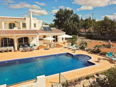 a large swimming pool in front of a house at Villa Santa Barbara by Portucasa in Bordeira