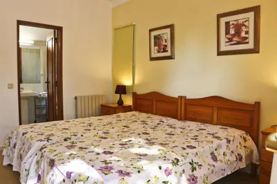 a bedroom with a bed with a floral bedspread at Villa Santa Barbara by Portucasa in Bordeira