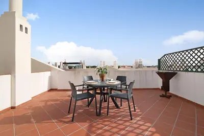 a patio with a table and chairs on a balcony at Apartamento Old Village T2 Duplex in Quarteira
