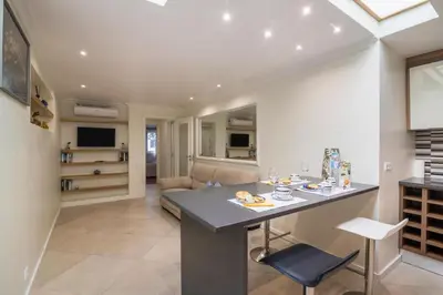 a kitchen and living room with a table and chairs at Apartamento Malick by Sunnyway in Branqueira