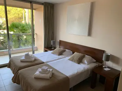 two beds in a hotel room with towels on them at Salgados - Vila das Lagoas in Guia