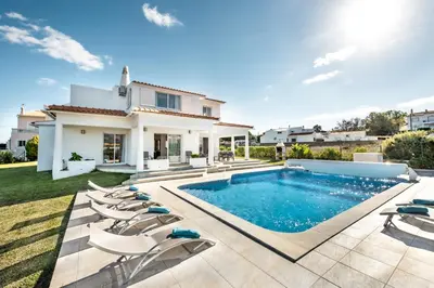a villa with a swimming pool and chairs at Silva by Algarve Villa Holidays in Albufeira
