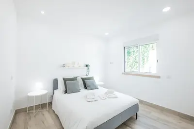 a white dining room with a white table and chairs at #074 Casa dos Arcos by Home Holidays in Albufeira