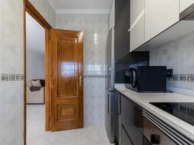 a kitchen with a wooden door and a microwave at Akisol Albufeira Water in Albufeira