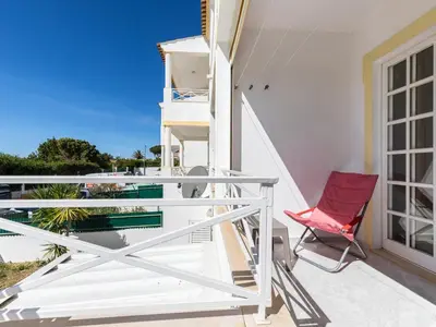 a red chair sitting on the balcony of a house at Akisol Albufeira Water in Albufeira