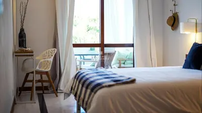 a bedroom with a bed and a window and a chair at Apartment Salgados Lounge - By Dalma Portuguesa in Albufeira