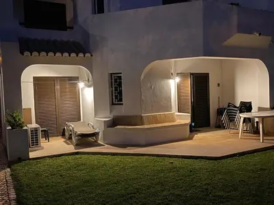 a patio with a table and chairs at night at Casa Sophie Albufeira in Albufeira