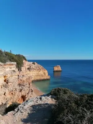 a beach with two large rocks in the water at Casa Sophie Albufeira in Albufeira