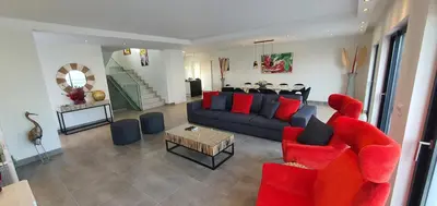 a living room with a couch and a table with red pillows at Sunrise Villa by Laranjal Rentals in Albufeira