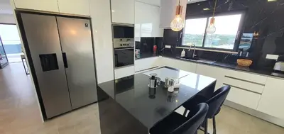 a kitchen with a black counter and chairs in it at Sunrise Villa by Laranjal Rentals in Albufeira