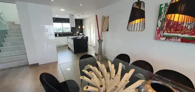 a kitchen and living room with a black table and chairs at Sunrise Villa by Laranjal Rentals in Albufeira