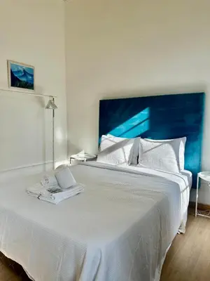 a large white bed with two white towels on it at Ti Maria Guest House in Faro
