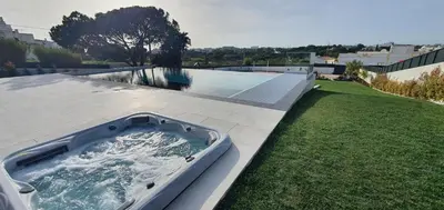 a hot tub sitting on the side of a yard at Sky Villa by Laranjal Rentals in Albufeira