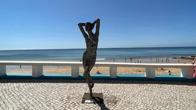 a statue of a woman standing next to a beach at Mosqueira by Check-in Portugal in Albufeira