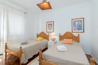 two twin beds in a room with white walls at Apartment Marina in Albufeira