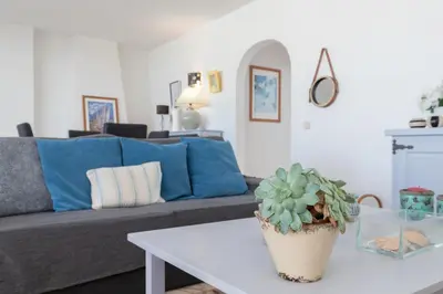 a living room with a couch and a table with a potted plant at Apartment Marina in Albufeira