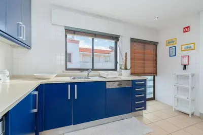 a blue kitchen with a sink and a window at Apartment Marina in Albufeira