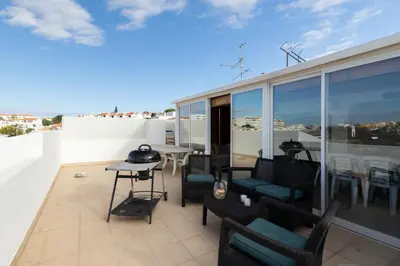 a balcony with chairs and tables on a roof at Apartment Marina in Albufeira