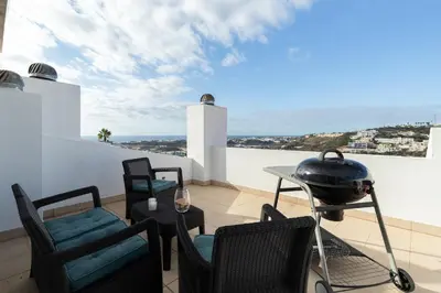 a patio with chairs and a grill on a balcony at Apartment Marina in Albufeira