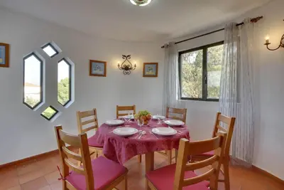 a dining room with a table with a purple table cloth at Villa Coelho in Albufeira