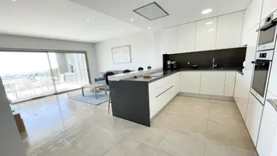 a kitchen with white cabinets and a black counter top at Alvorada Premium by Sunny Deluxe in Albufeira