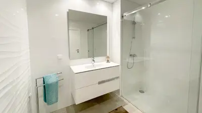 a white bathroom with a sink and a shower at Alvorada Premium by Sunny Deluxe in Albufeira