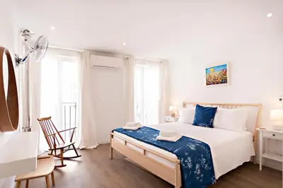 a white bedroom with a large bed and a desk at Casa da Vila in Faro