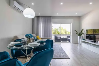 a dining room with a table and blue chairs at Casa Santa Maria - Sea View - 500m from the Beach - WiFi in Albufeira
