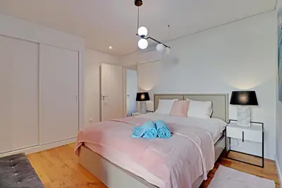 a bedroom with a bed with two blue towels on it at Dubai Apartment in Vilamoura