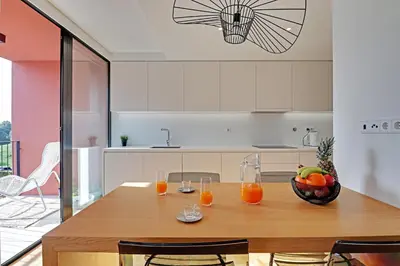 a kitchen with a wooden table with glasses of orange juice at Dubai Apartment in Vilamoura