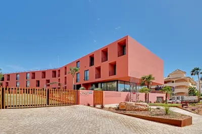 a red building with a fence in front of it at Dubai Apartment in Vilamoura